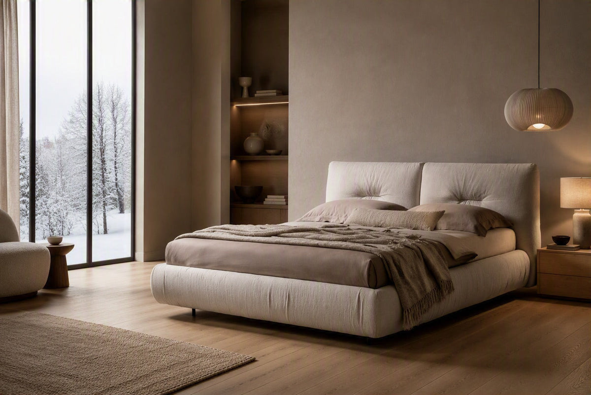 A neutral cream coloured bed in a Scandi bedroom with winter background outside