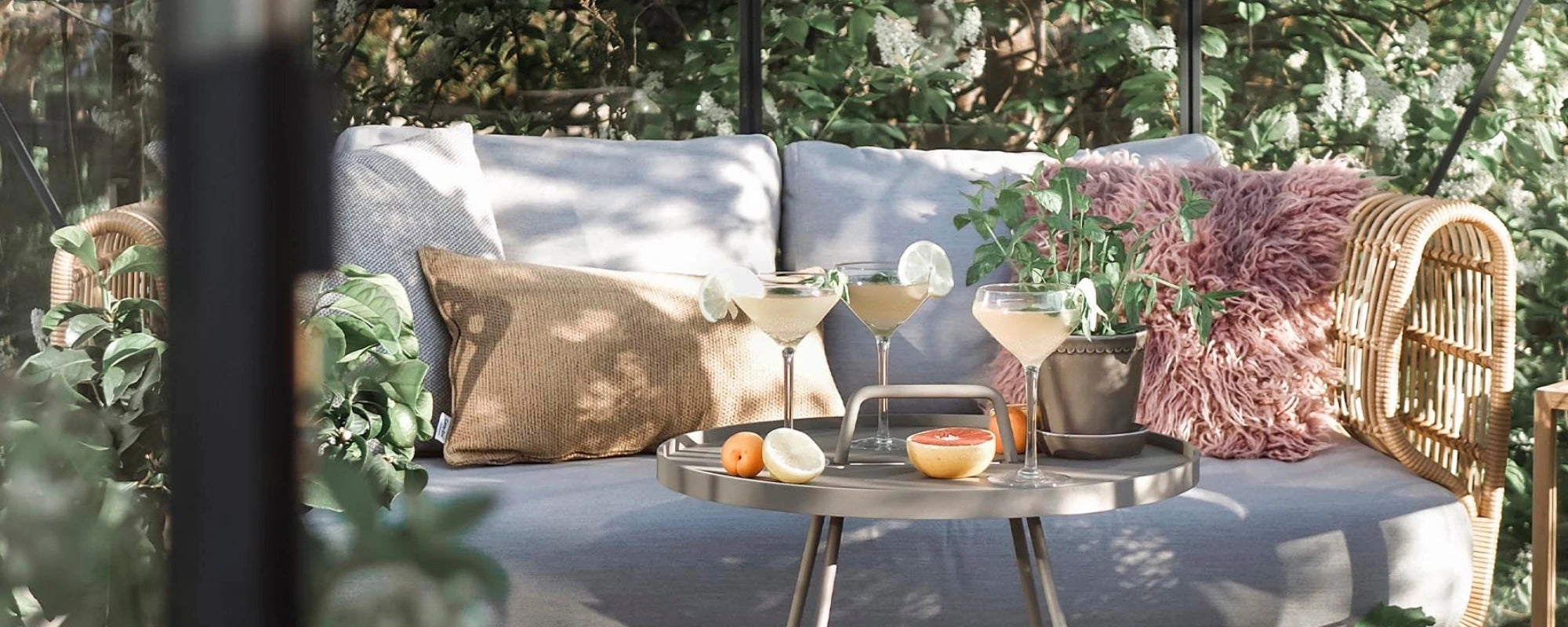 Outdoor seating area with a sofa, cushions, and a small table with decorative items.